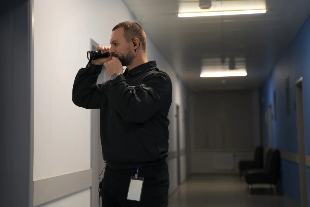 Agent de sécurité en poste surveillant son espace de travail avec talkie-walkie