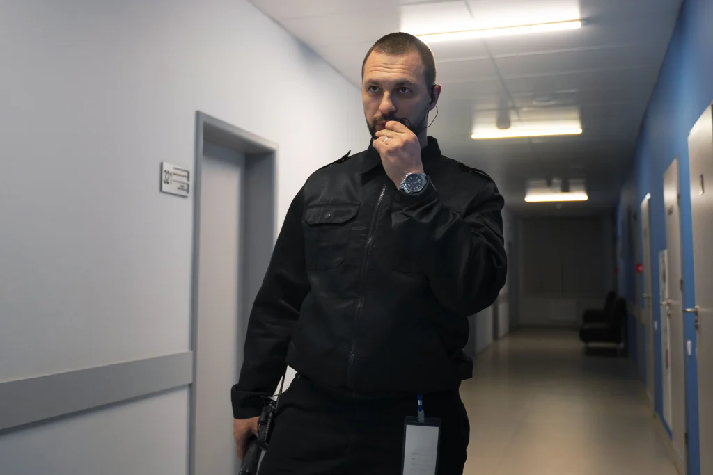 Agent de sécurité en poste surveillant son espace de travail avec talkie-walkie